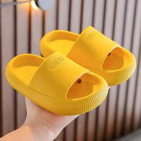 Colourful children's EVA slippers with a textured non-slip sole, shown in blue, green, orange, pink and yellow.