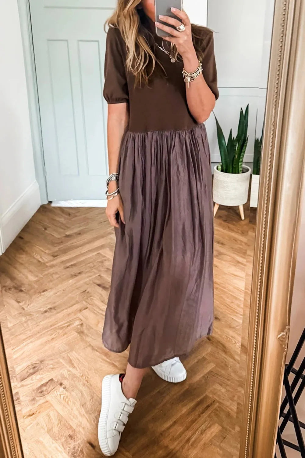 Woman wearing a coffee-coloured knitted patchwork dress with high waist and short sleeves