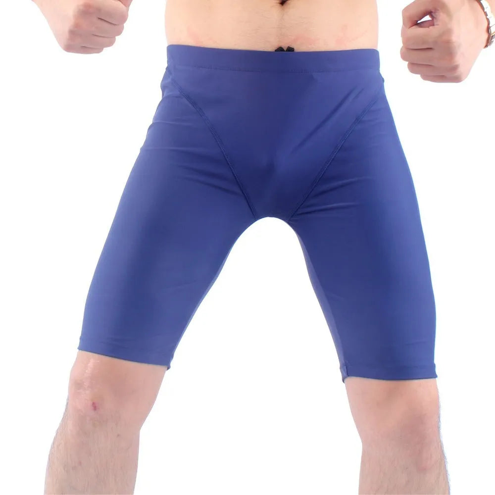 Green and navy blue men's loose-fit swimming trunks with a five-point design and polyester lining.