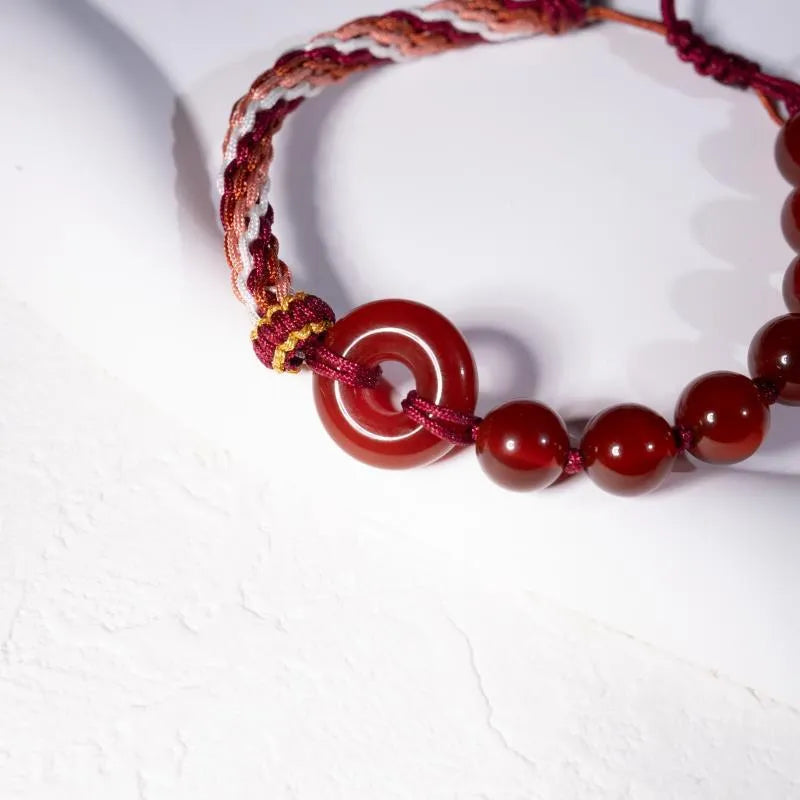Red agate carrying strap bracelet with elk element on neutral background