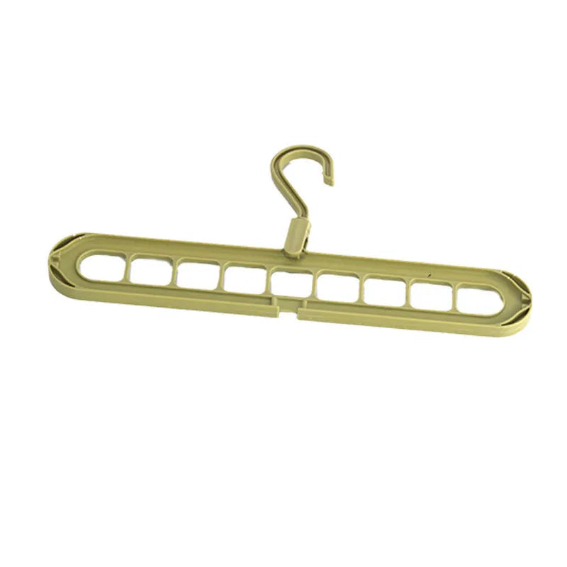 Green plastic nine-hole multifunctional clothes hanger for trousers on a white background.