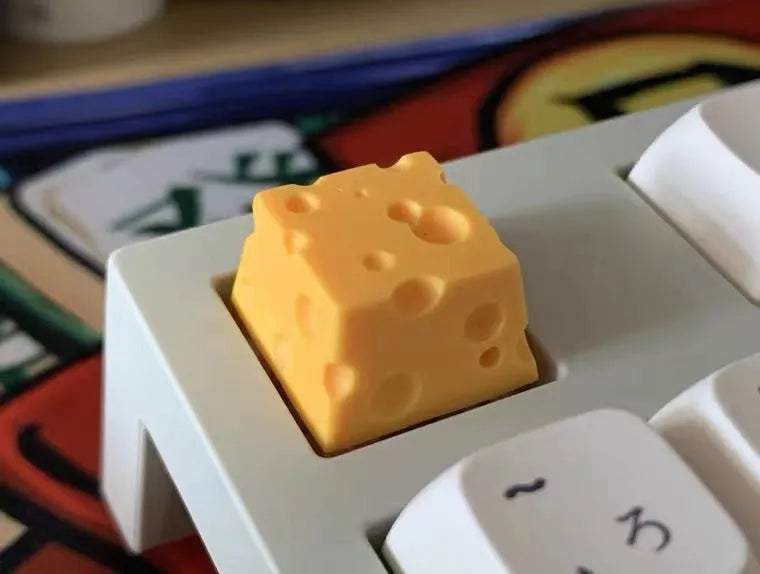 Yellow resin mechanical keyboard keycap with a detailed cheese design for MX-style switches.