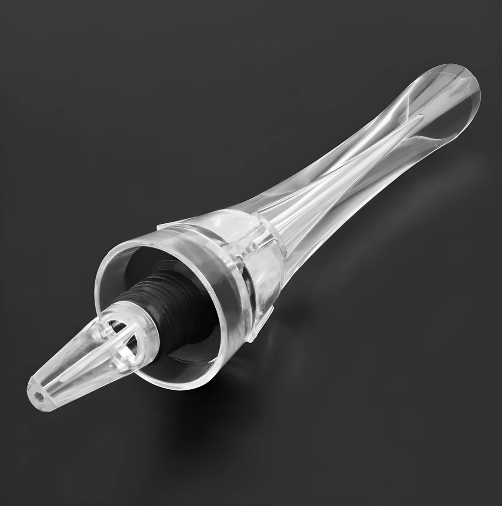 A clear acrylic wine aerator with a stainless steel filter, shown next to a wine glass.