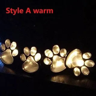 Four black paw print solar garden lights connected to central solar panel pole