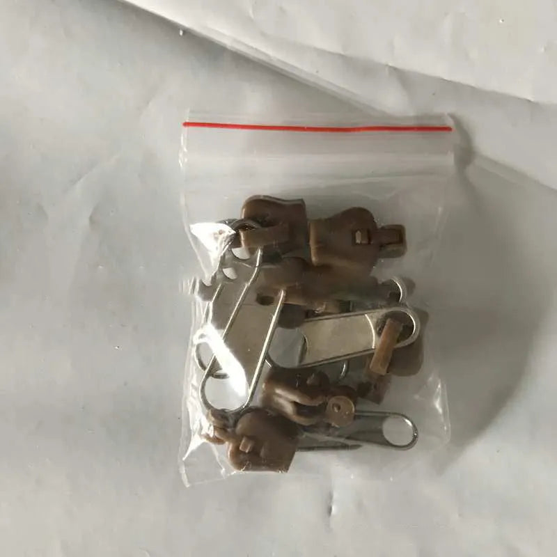 Pack of 12 reusable zipper head slider clips in assorted colours for repairing broken zippers.