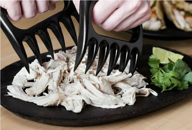 Black bear claw meat shredder utensil for pulling pork and chicken on a kitchen surface.