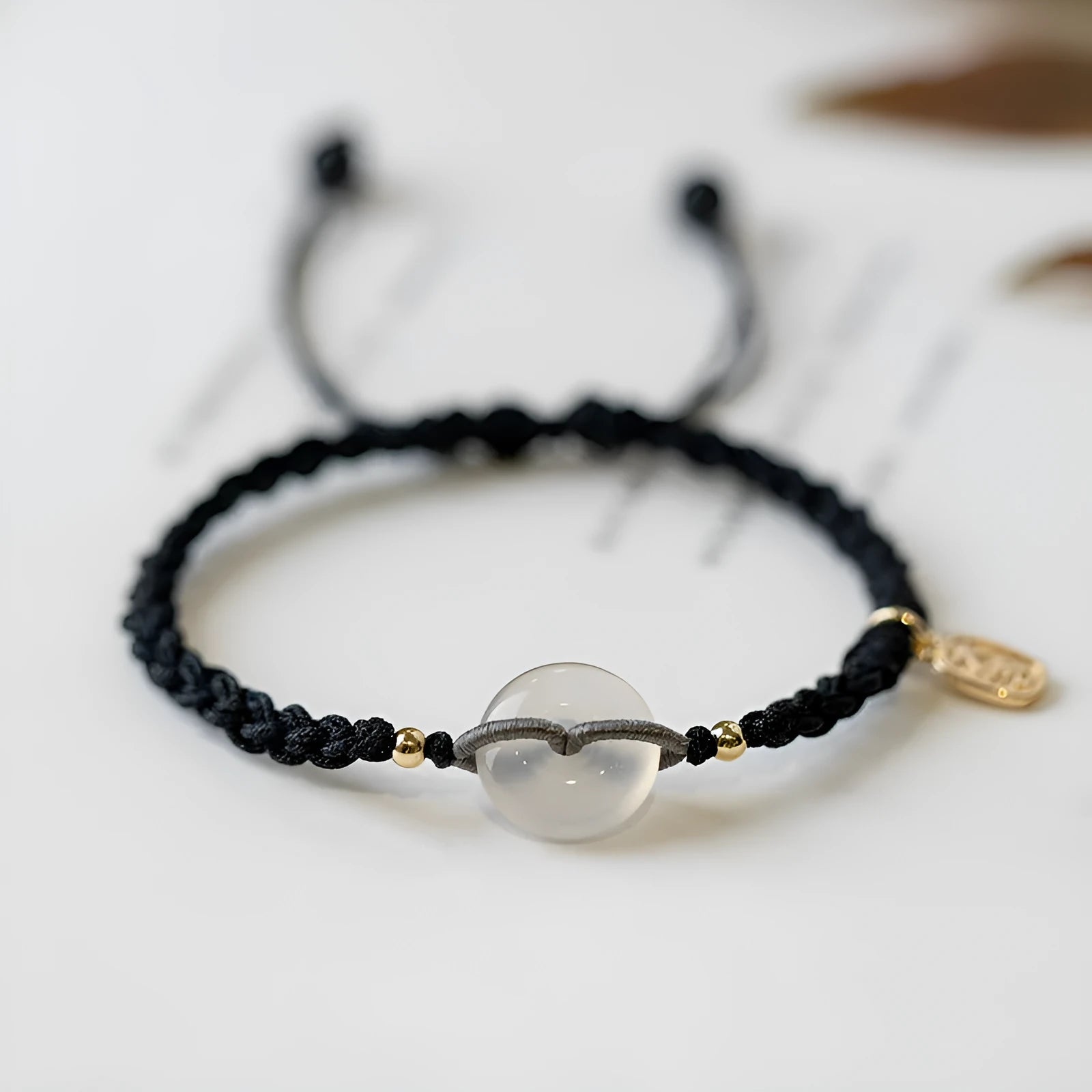 Crystal bracelet with woven rope strap and geometric square grain detailing in ethnic style