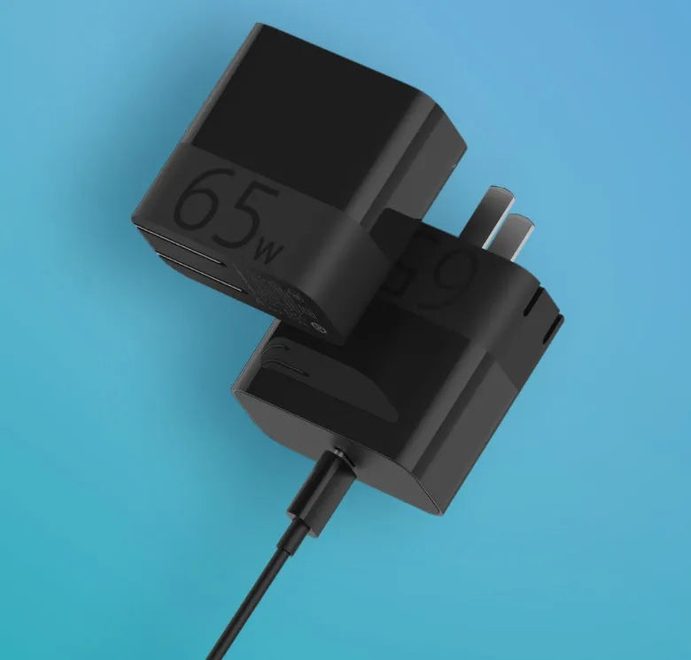Black ZMI USB-C 65W compact laptop power adapter showing size comparison
