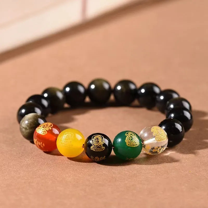 Close-up of a polished crystal bracelet with rainbow eye obsidian beads in a single circle design on a wrist.
