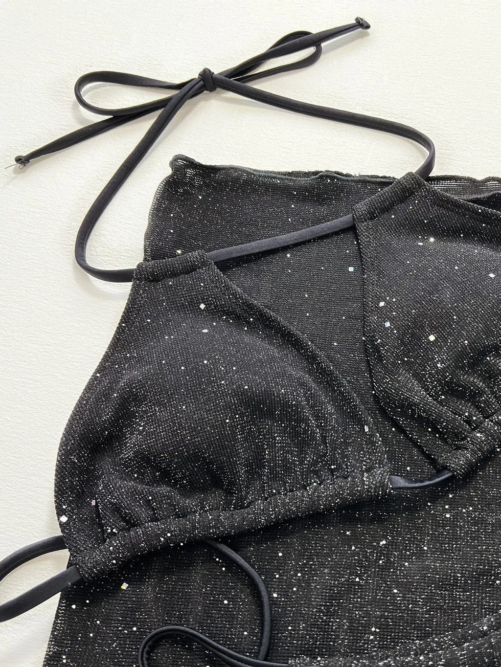 Black three-piece swimsuit bikini set with high-waisted shorts on mannequin