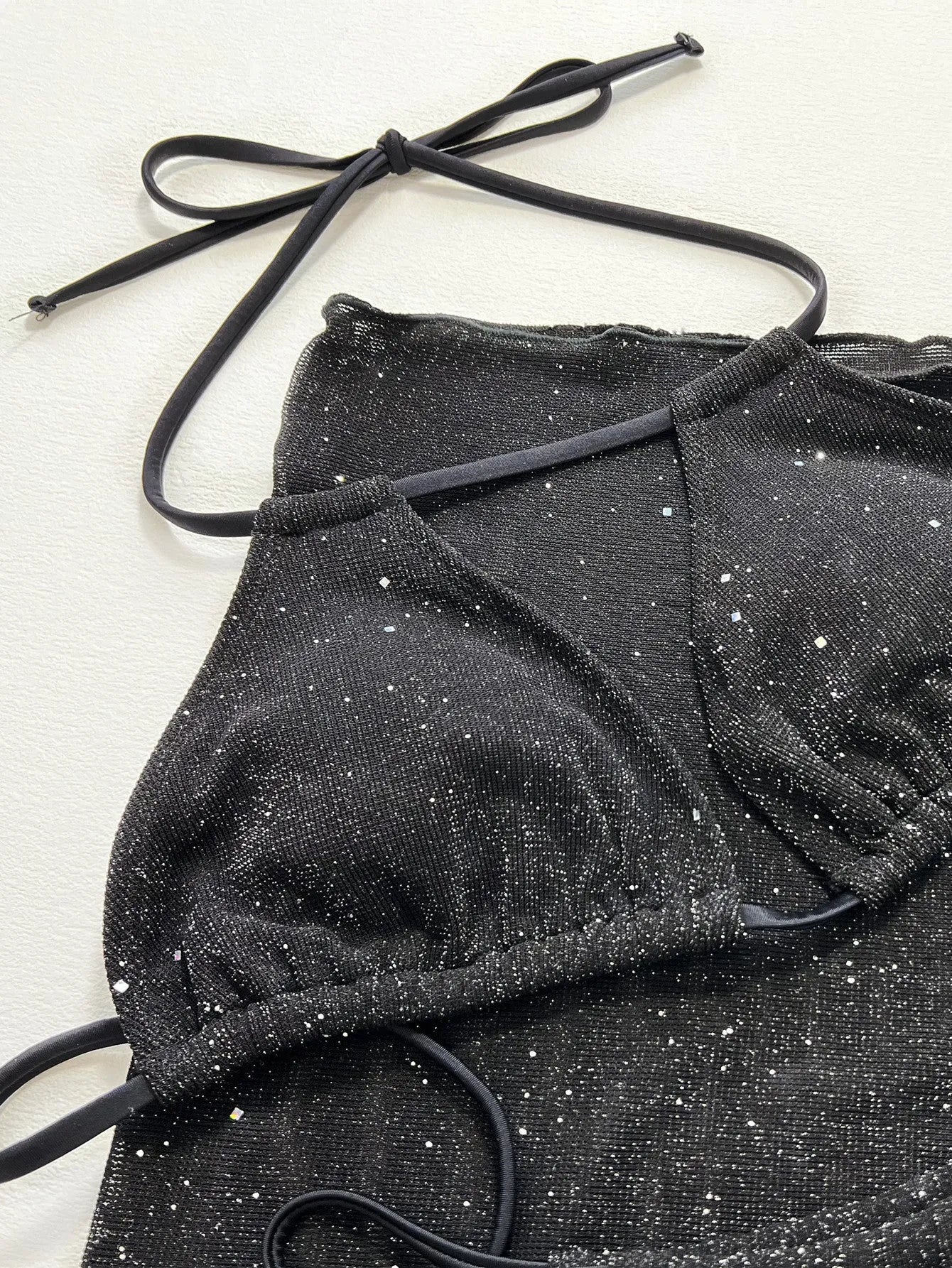 Black three-piece swimsuit bikini set with high-waisted shorts on mannequin
