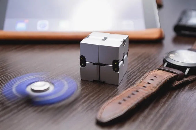 Black zinc alloy infinity cube fidget toy showing eight connected cubes.