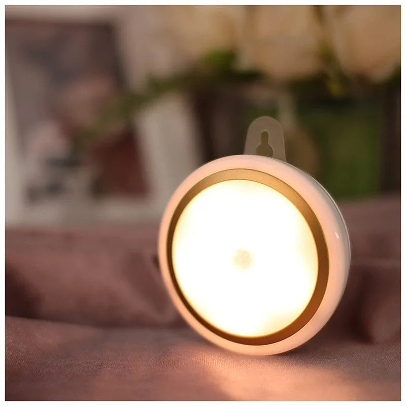 Compact round motion sensor LED light with 80mm diameter, shown in a wardrobe setting.