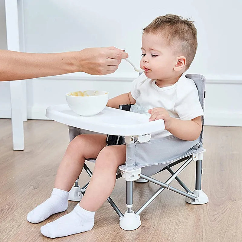 Foldable baby dining chair with safety belt, removable tray, and storage bag in pink