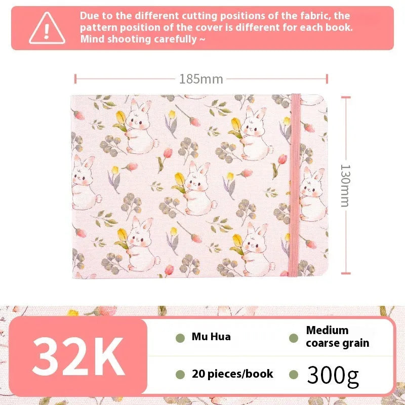 Feiluniao handmade fabric watercolour notebook with illustrated cover, open to show blank paper pages.