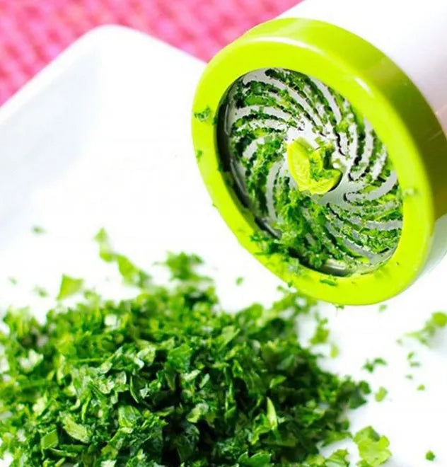 White and silver herb grinder spice mill with removable top on a kitchen counter.