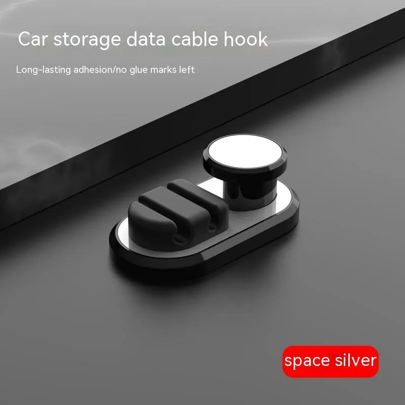 Dark green ABS silicone car cable hook with adhesive backing for organising data cables on a dashboard.
