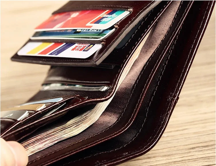 Men's black leather bi-fold wallet open to show card slots, banknote compartment, and coin pocket.