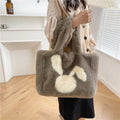 Soft beige plush tote bag with cartoon rabbit ears on the front, shown as a large capacity shoulder bag.