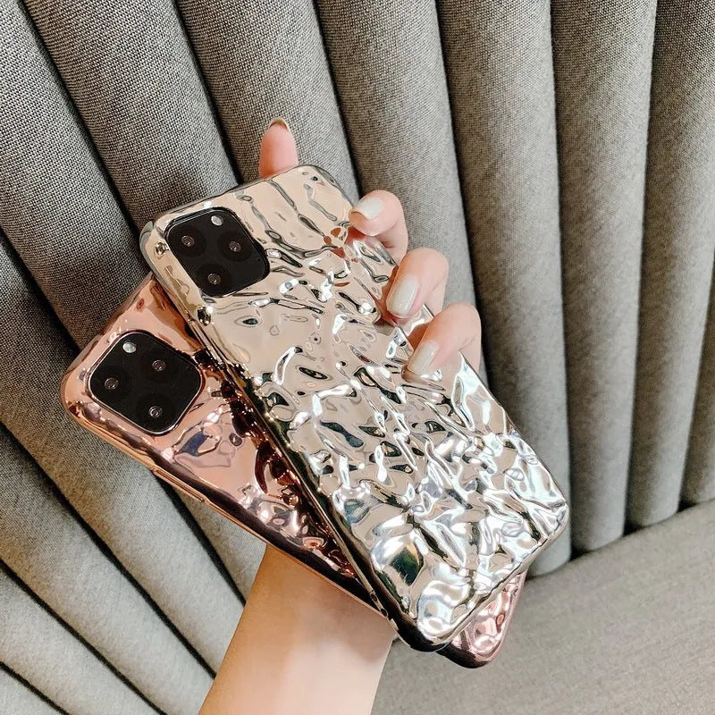 Rose gold and silver folded TPU back cover cases for various iPhone models on a plain surface.