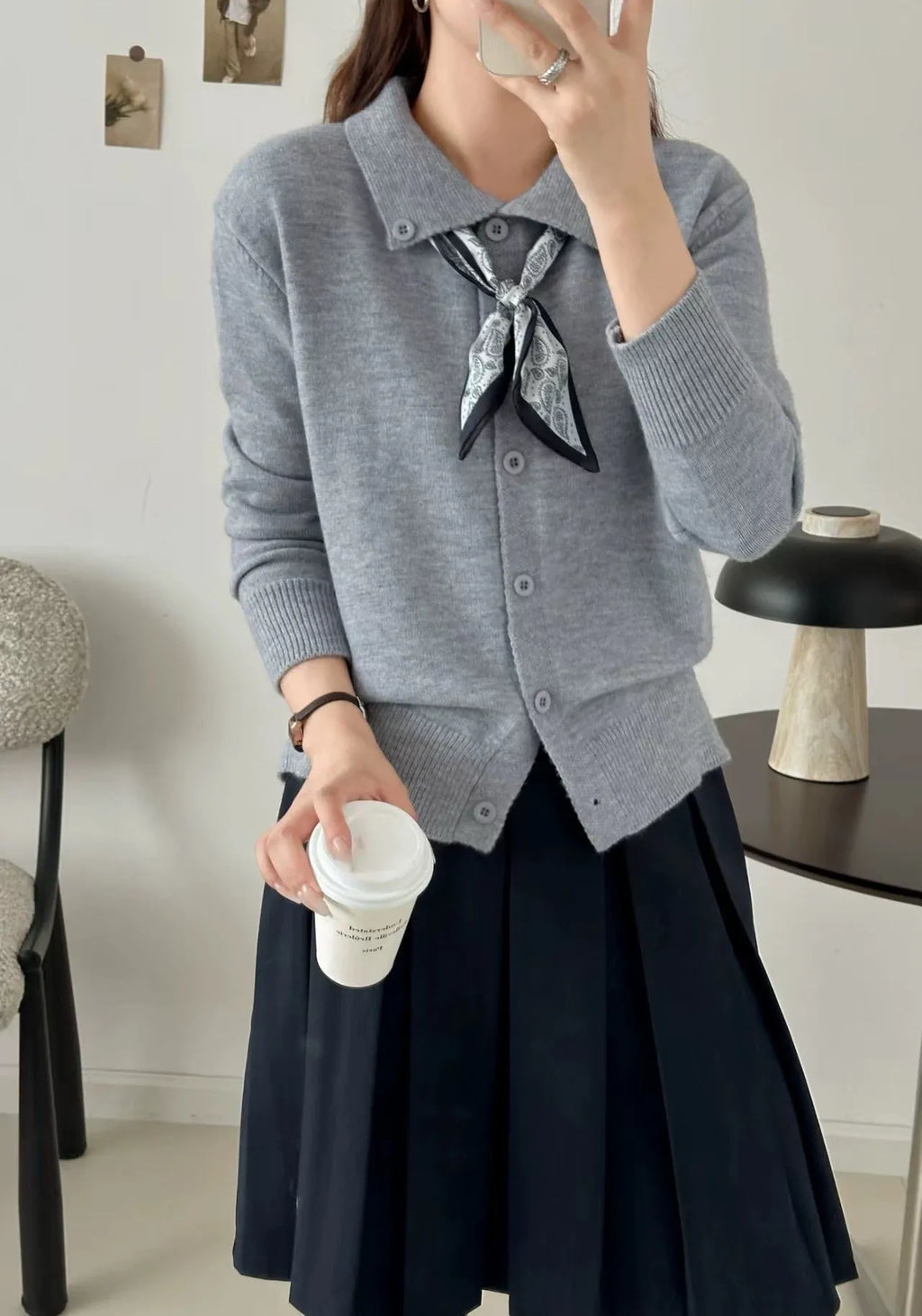 Milky white acrylic fibre cardigan sweater with a lapel scarf and long sleeves laid flat