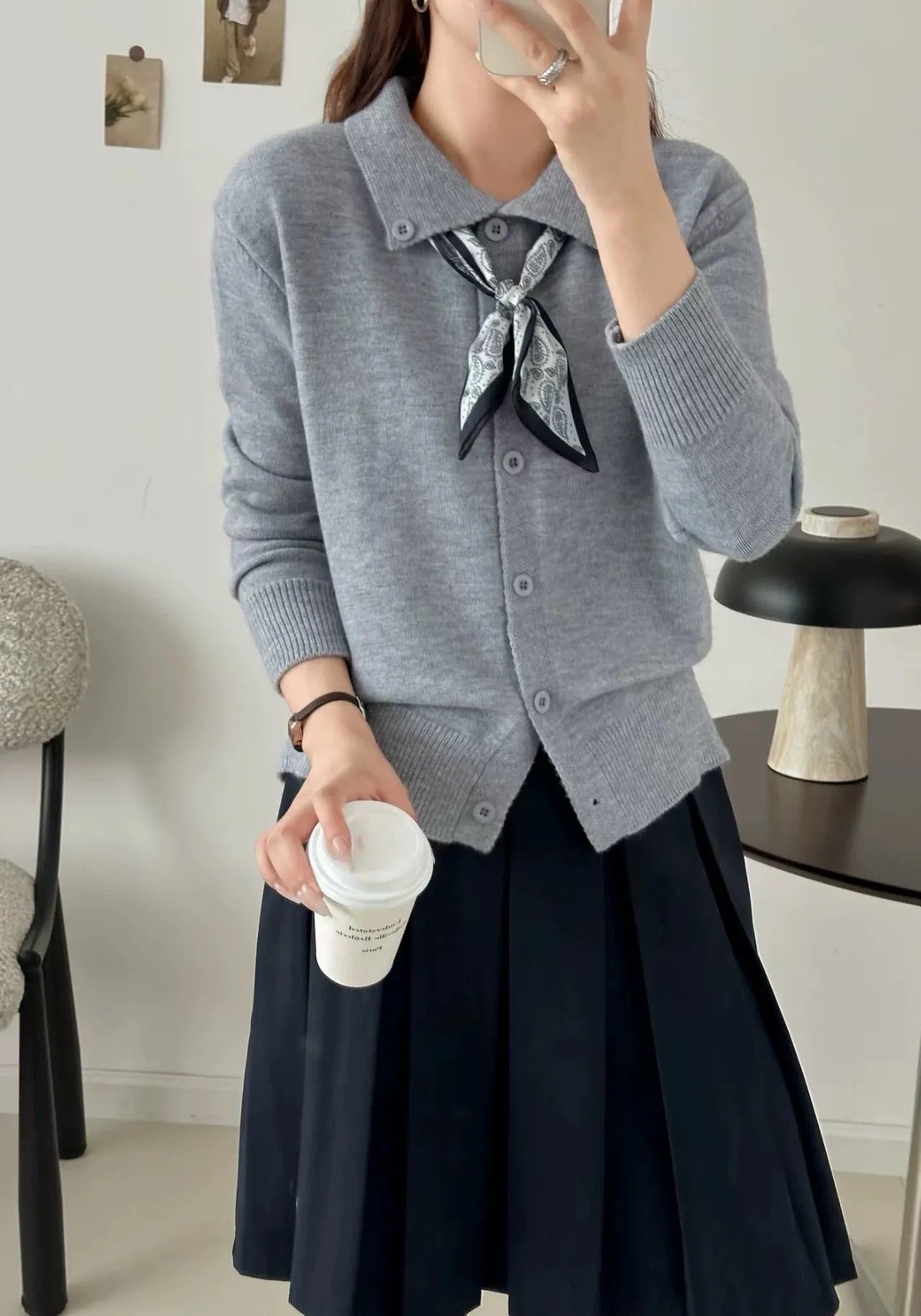 Milky white acrylic fibre cardigan sweater with a lapel scarf and long sleeves laid flat