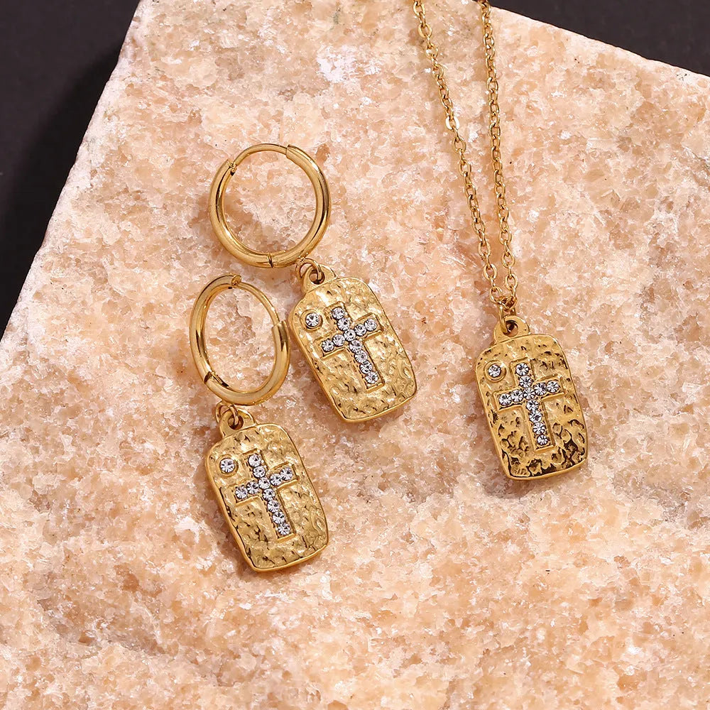 Gold micro inlay rhinestone cross hammer necklace on woman with quadrilateral geometric pendant on stainless steel chain