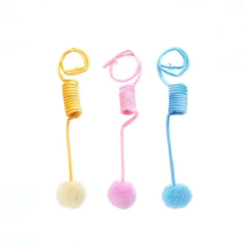 Blue cat toy with suction cup, spring rabbit fur ball, and retractable elastic rope on a door surface