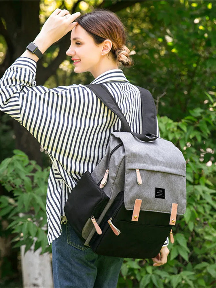 Land Mommy large oxford cloth diaper backpack in grey with a changing mat, shown open.