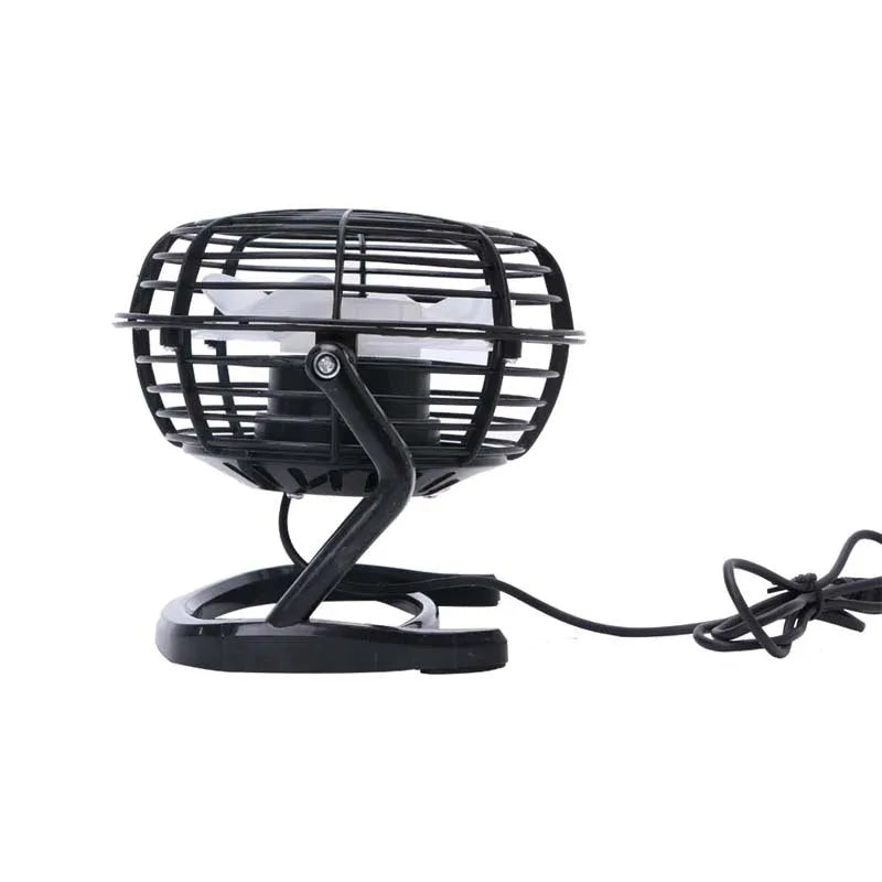 Small black USB desk fan with adjustable tilt on a wooden desk next to a laptop