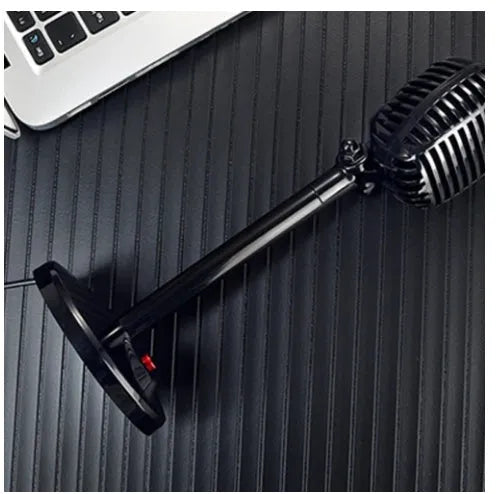Black USB condenser microphone with stand, adjustable neck, and foam windscreen, placed on a desk