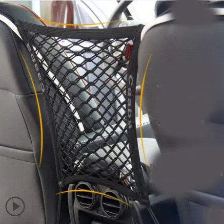 Black elastic nylon car pet fence isolation net installed on middle seat with hooks.