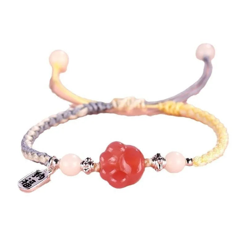 Red cat's paw glass bead on a handmade pink woven bracelet for couples.