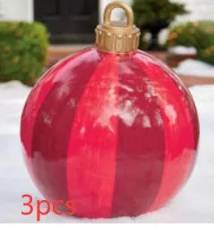 Large red and white striped inflatable Christmas ball ornament hanging on an outdoor tree