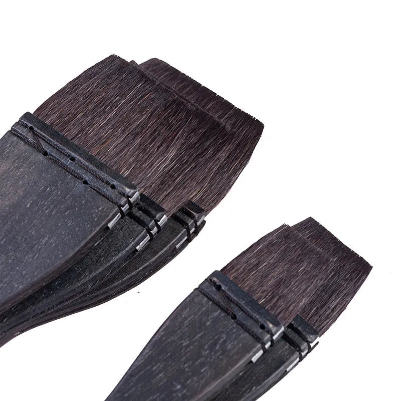 Grey squirrel hair artist paint brush with a light wood handle on a white background