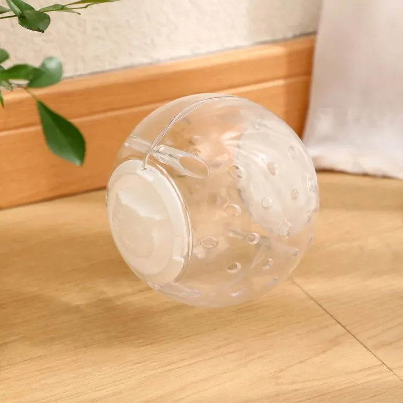 Clear blue ABS plastic slow feeder ball for cats, 11.5cm in diameter, on a wooden floor.