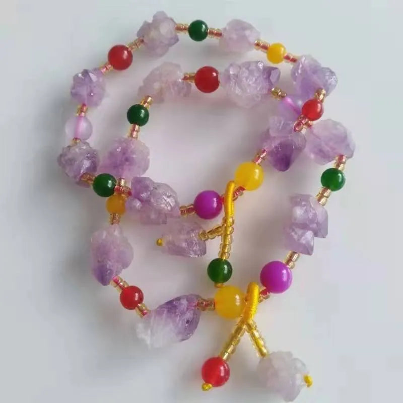 Women's natural amethyst bead bracelet with a fu character charm on a white background.