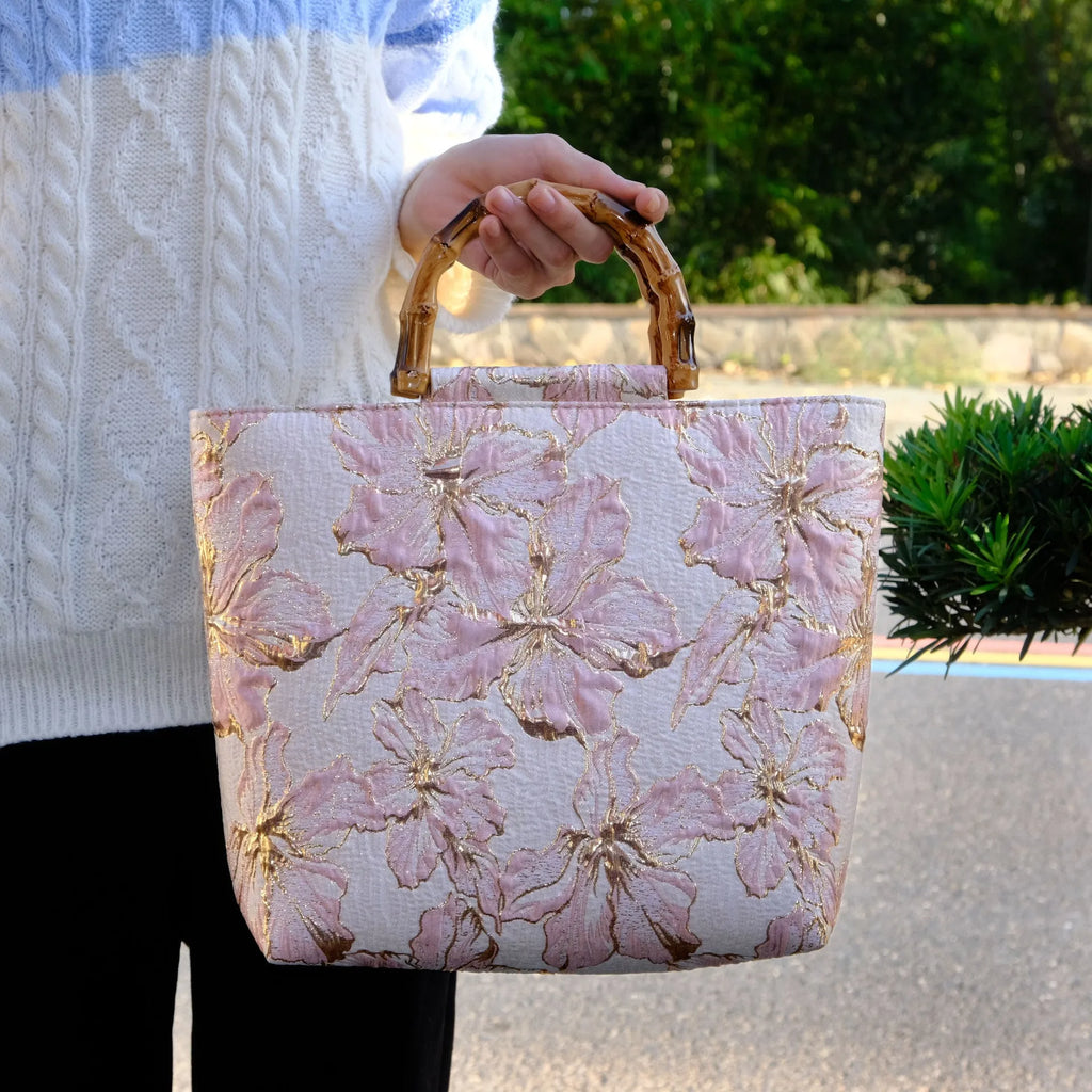 Women's light blue canvas shoulder bag with bronzing flower detail showing horizontal square shape and double straps