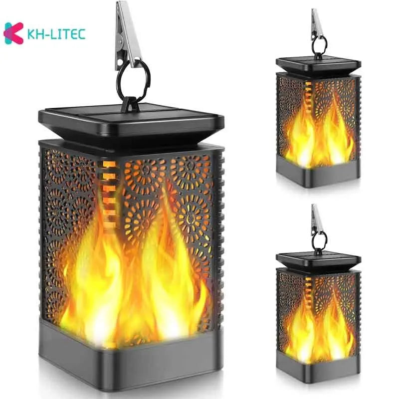 Set of four black solar-powered flame effect LED lanterns for outdoor garden decoration.