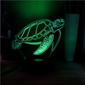 3D acrylic turtle-shaped LED night light with colour-changing illumination on a surface.