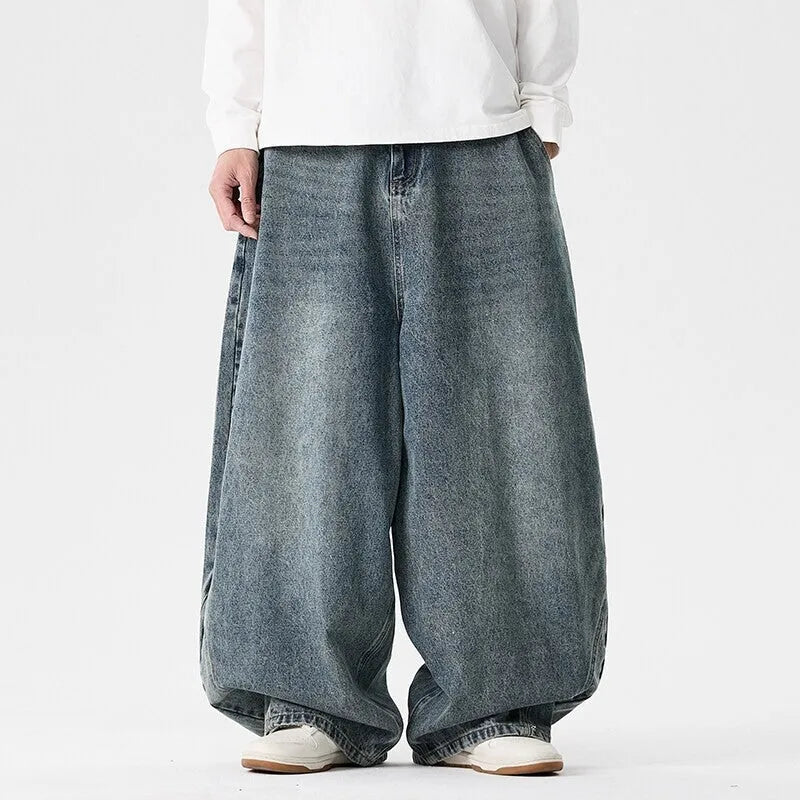 Men's plus-size light blue wide-leg baggy denim jeans on a hanger.