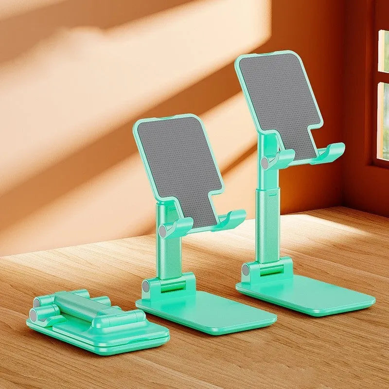 White folding telescopic mobile phone bracket holding a smartphone on a desktop.