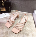 Women's white thick high heel slip-on sandals with a backless design on a plain background.