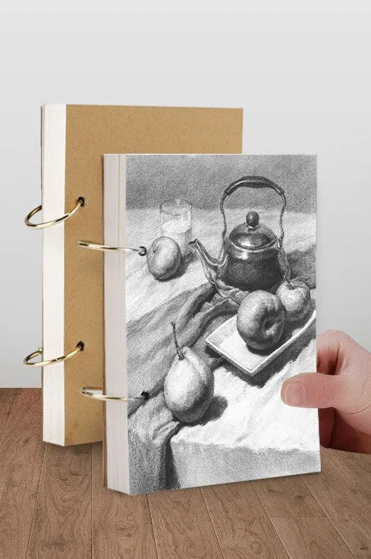 8K thickened sketchbook open on a table with marker drawings, showing linen and black card cover options.