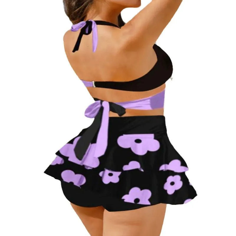 Women's black lace-up bikini top with matching high-waist swim skirt laid flat.