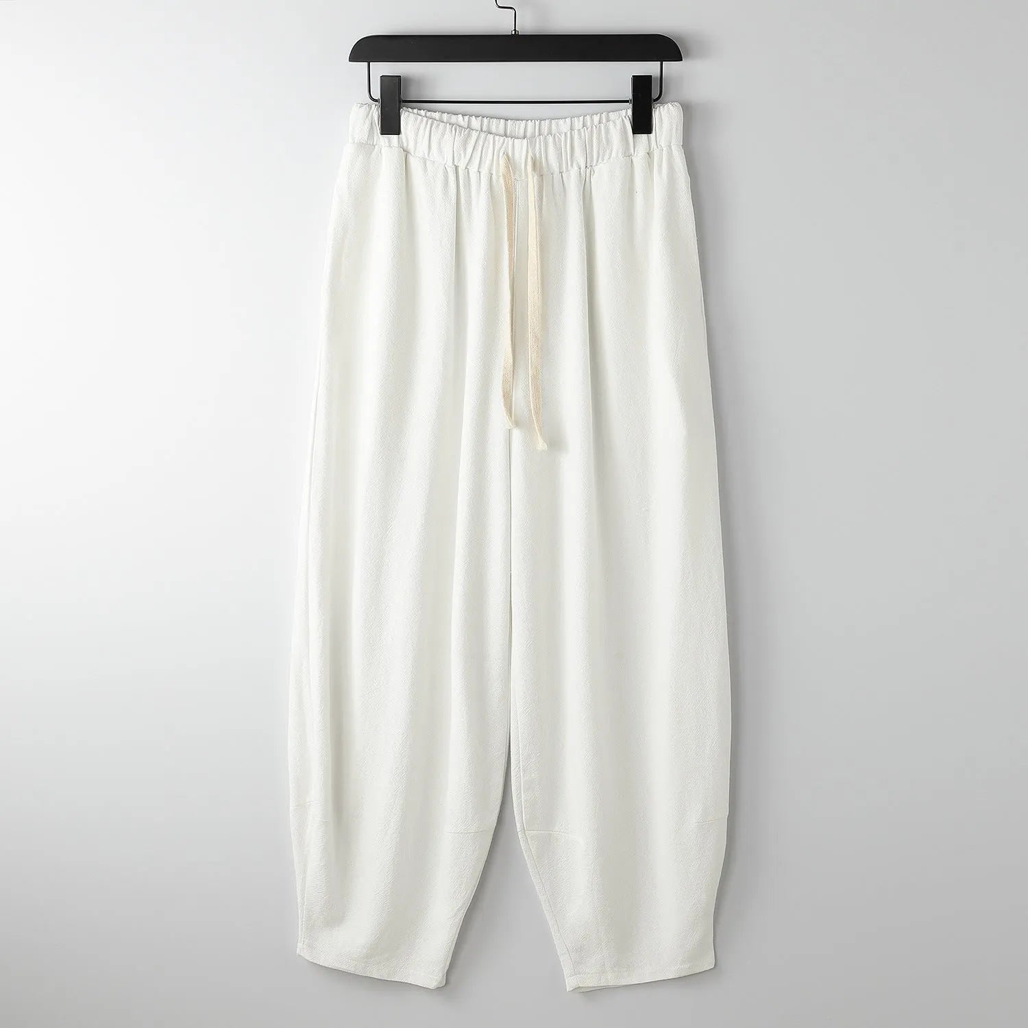 Men's linen harem pants with ankle ties in tapered loose fit on larger model