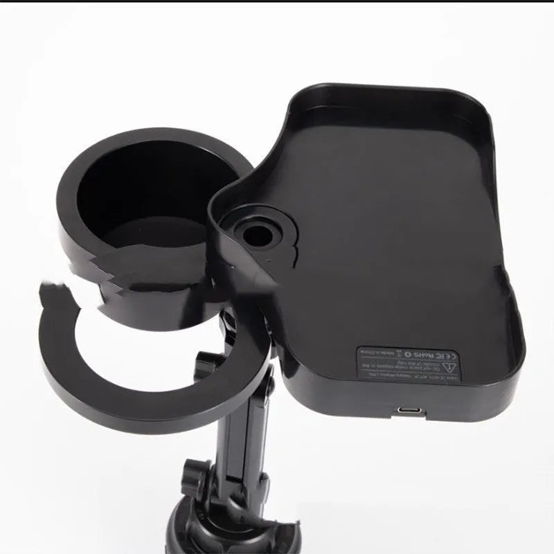 Black car cup holder with wireless charging pad and USB outlet, placed on a vehicle instrument panel.