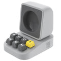 Silicone watch charger bracket in typewriter shape in grey, purple, and yellow colours on a desk