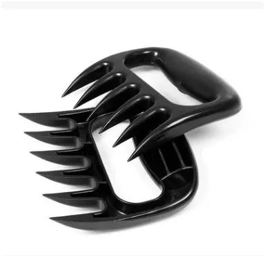 Black bear claw meat shredder utensil for pulling pork and chicken on a kitchen surface.
