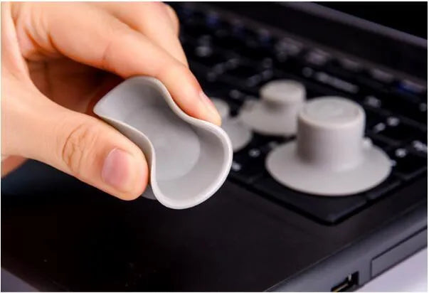 Four grey plastic laptop cooling pads, two large and two small, on a flat surface.